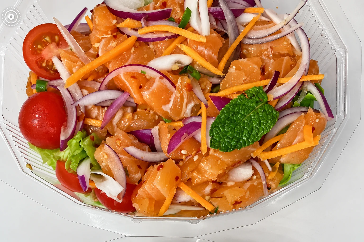 Salmon salad with lemongrass in a transparent box
